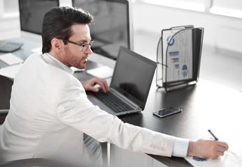 businessman writing down information in a notebook