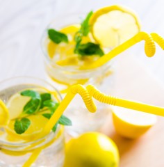 Glasss of mojito with lemon and drinking straw