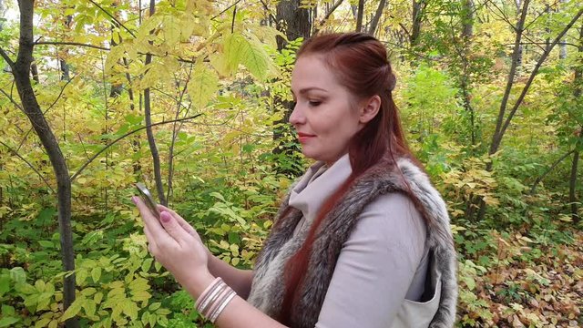 glamorous woman in autumn Park with phone