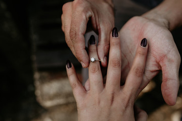 Man putting engagement ring on female hand