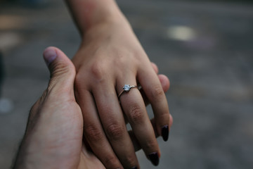 Man holding female hand with the engagement ring