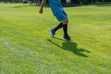 cropped view of kid running on green grass