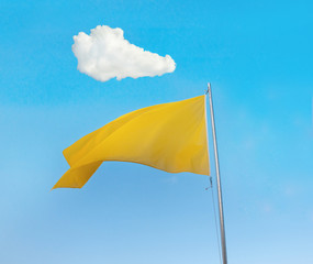 Yellow flag over blue sky with a white cloud above