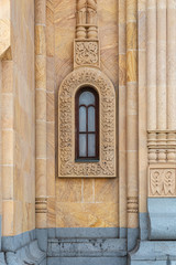 Narrow arched window, carved in stone