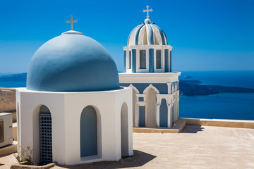 Domes on the rooftop of the Church of St. Mark the Evangelist and the Aegean Sea on the Fira City at Santorini Island - obrazy, fototapety, plakaty