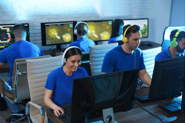 Young people playing video games on computers indoors. Esports tournament