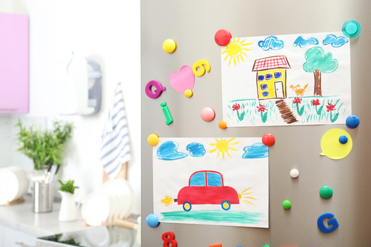 Child's drawings and magnets on refrigerator door
