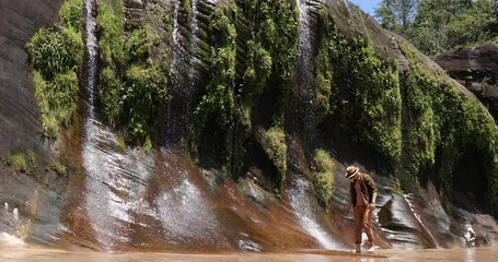 Male tourists walking with beautiful waterfalls, handsome man with nature, travel nature, waterfalls in Thailand