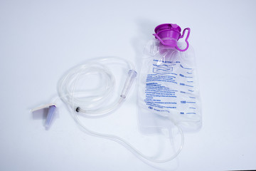 Feeding Pump medical device purple color to supplement nutrition liquid food to tube Enteral feeding fluid set bag with clamp hanging on stand.