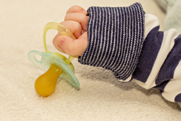 Close up of baby little hand with pacifier dummy