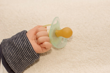 Close up of baby little hand with pacifier dummy