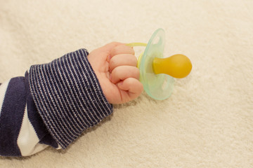 Close up of baby little hand with pacifier dummy