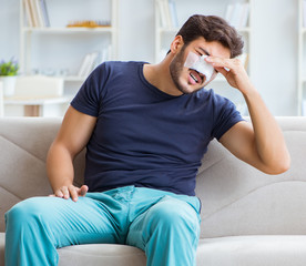 Fototapeta premium Young man recovering healing at home after plastic surgery nose