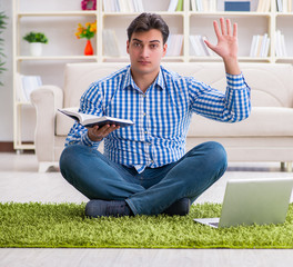 Young handsome man sitting on floor at home