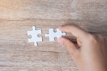 Businessman hand connecting couple puzzle piece. Business solutions, mission target, successful, goals, cooperation, partnership and strategy concept