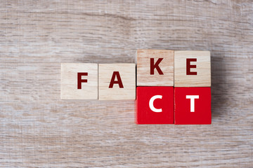 wooden cube with flip block FAKE to FACT word on table background. News, solution and business  concepts