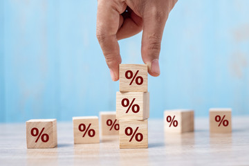 business man Hand putting wood cube block with percentage symbol icon. Interest rate,  financial,...