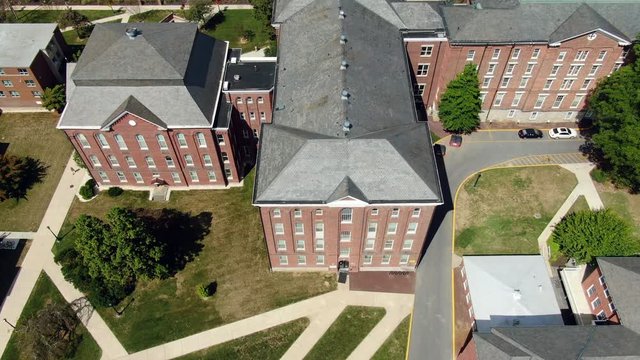 AERIAL TILT UP Revealing Brick Dormitories and Academic Buildings at college university campus