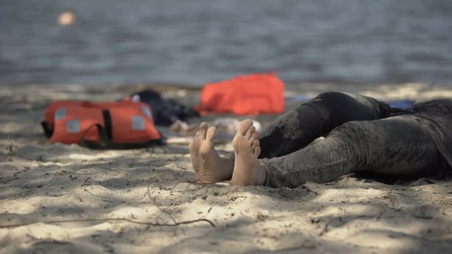 Muddy female legs crawling on shore, life jackets on background, surviving storm