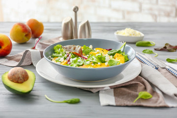 Plate with tasty salad on table