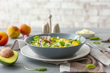 Plate with tasty salad on table