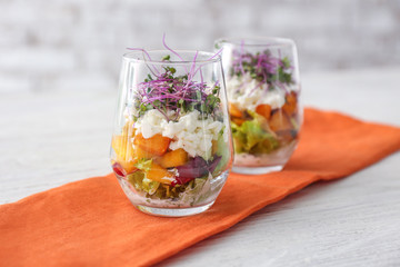 Glasses with tasty salad on table