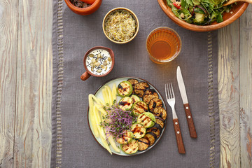Plate with tasty salad and glass of juice on table