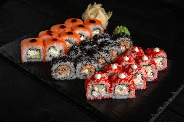 Sushi set with fresh ingredients on black background. Sushi menu. Japanese food. 