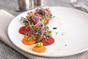 Plate with tasty salad on table, closeup