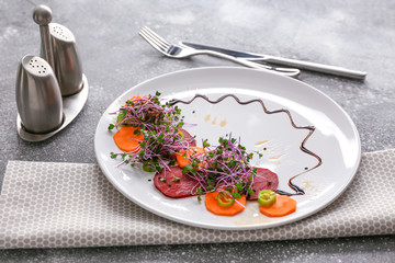 Plate with tasty salad on table