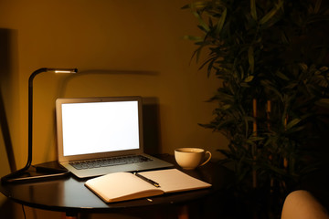 Modern workplace with laptop in evening