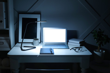 Fototapeta na wymiar Modern workplace with laptop in evening