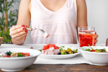 Woman eating fresh salad at table, closeup