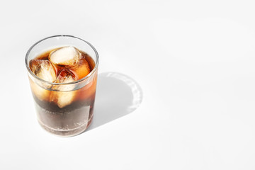 Glass of cold cola on light background