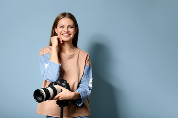 Beautiful female photographer on color background