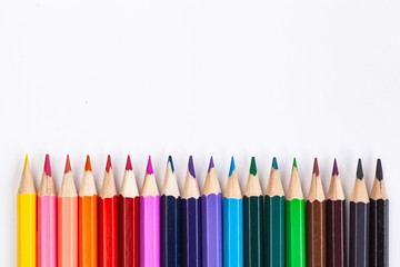 Set of colored pencils at the bottom of the frame in a row on a white background.