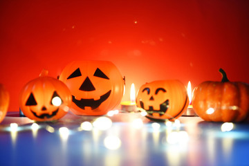 Halloween background candlelight orange decorated holidays festive concept - funny faces jack o lantern pumpkin halloween decorations for party accessories object with candle light bokeh