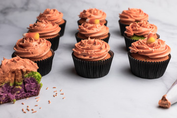 Chocolate halloween themed cupcakes, orange colored frosting, green and purple cupcake dough - 289956869