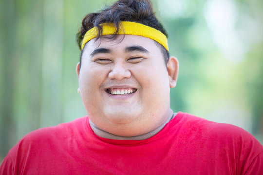 Smiling obese man wears sportswear in park
