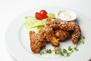 deep fried chicken wings with vegetables and a sauce