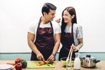 Happy couple cooking and preparing meal together in the kitchen