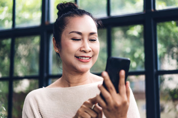 Portrait of happy senior adult elderly asia women smiling and using and talking on the phone at home.Retirement concept