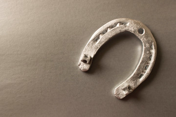 Silver horseshoe on a gray background. An old horseshoe. Close up.