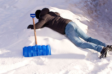 A teenager shoveling snow in his yard. The concept of a snowy winter.
