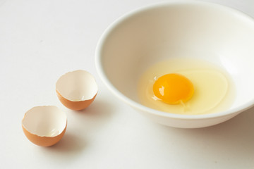 Fresh raw egg in bowl on white background.