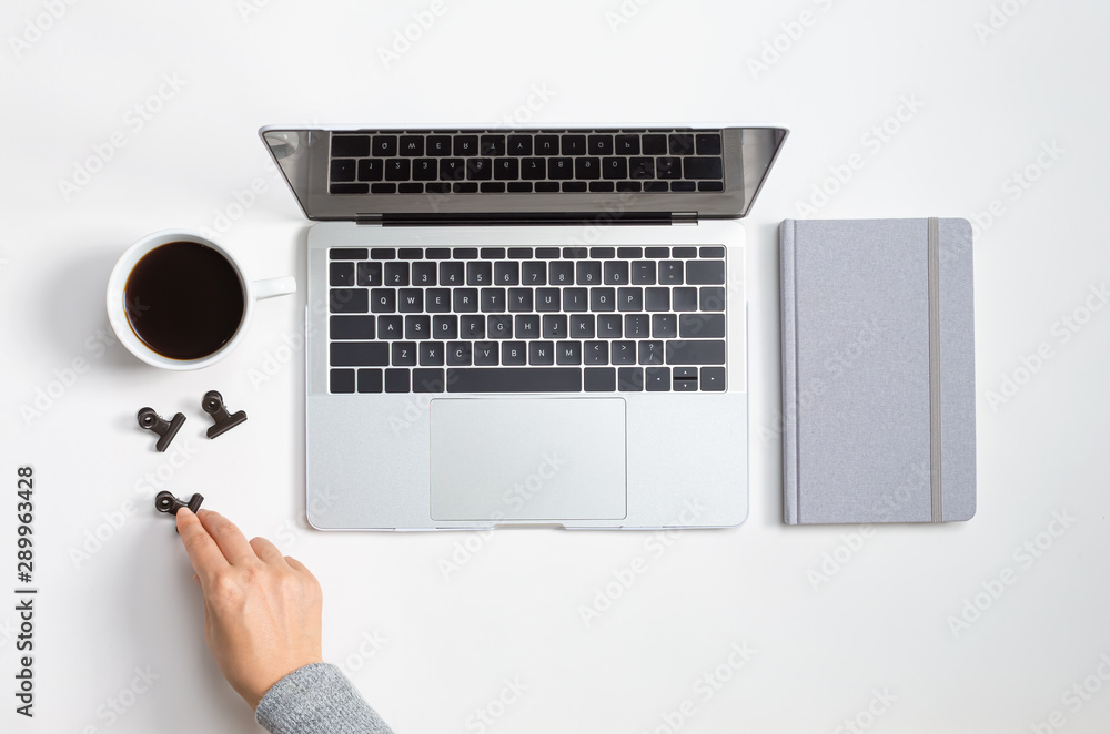 Poster person using a laptop computer with a notebook