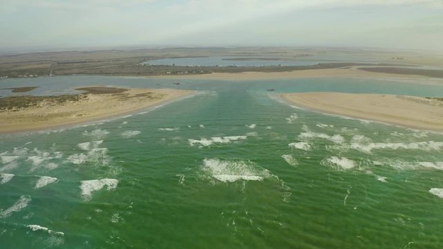 Drone video of Murray Mouth, Coorong, South Australia, Australia, travelling from the sea through the Murray mouth and over dredging equipment, ending at family with dog