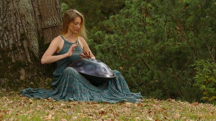 Playing The Instrument Hung. Woman Hands Playing The Hang outdoors.
