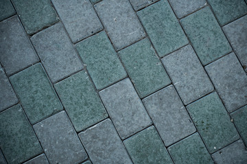 Texture of paving slabs overgrown with grass. Background image of a stratum stone