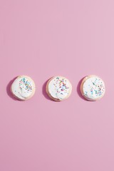 Three cookies on pink table